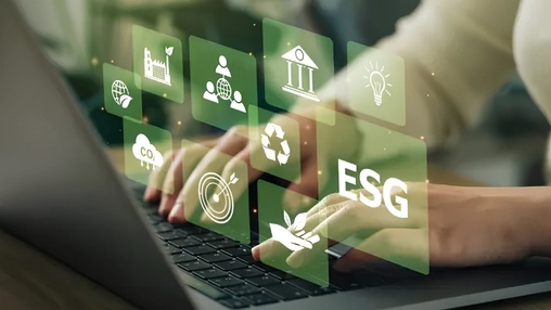 Hands on laptop keyboard with green digital ESG icons and sustainability symbols hovering above the screen