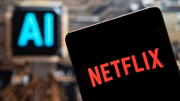Netflix logo on a smartphone screen with an illuminated AI sign visible in the blurred background